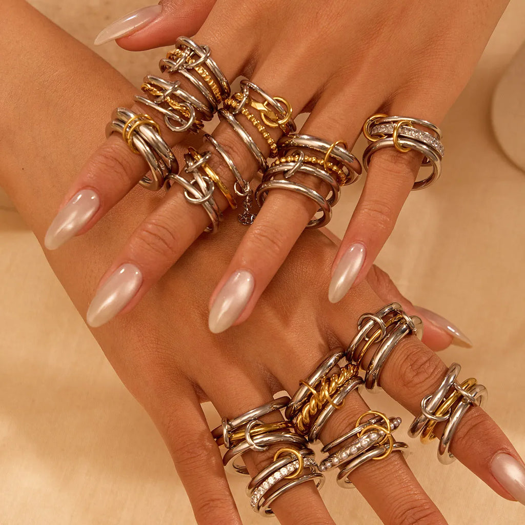 Stacked stainless steel rings with 18K gold plating in three colour variations, showing adjustable free size design