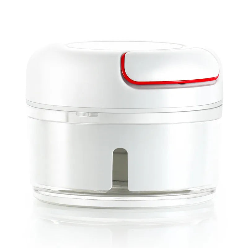White manual food chopper with stainless steel blades on a magnetic holder, shown with chopped vegetables.