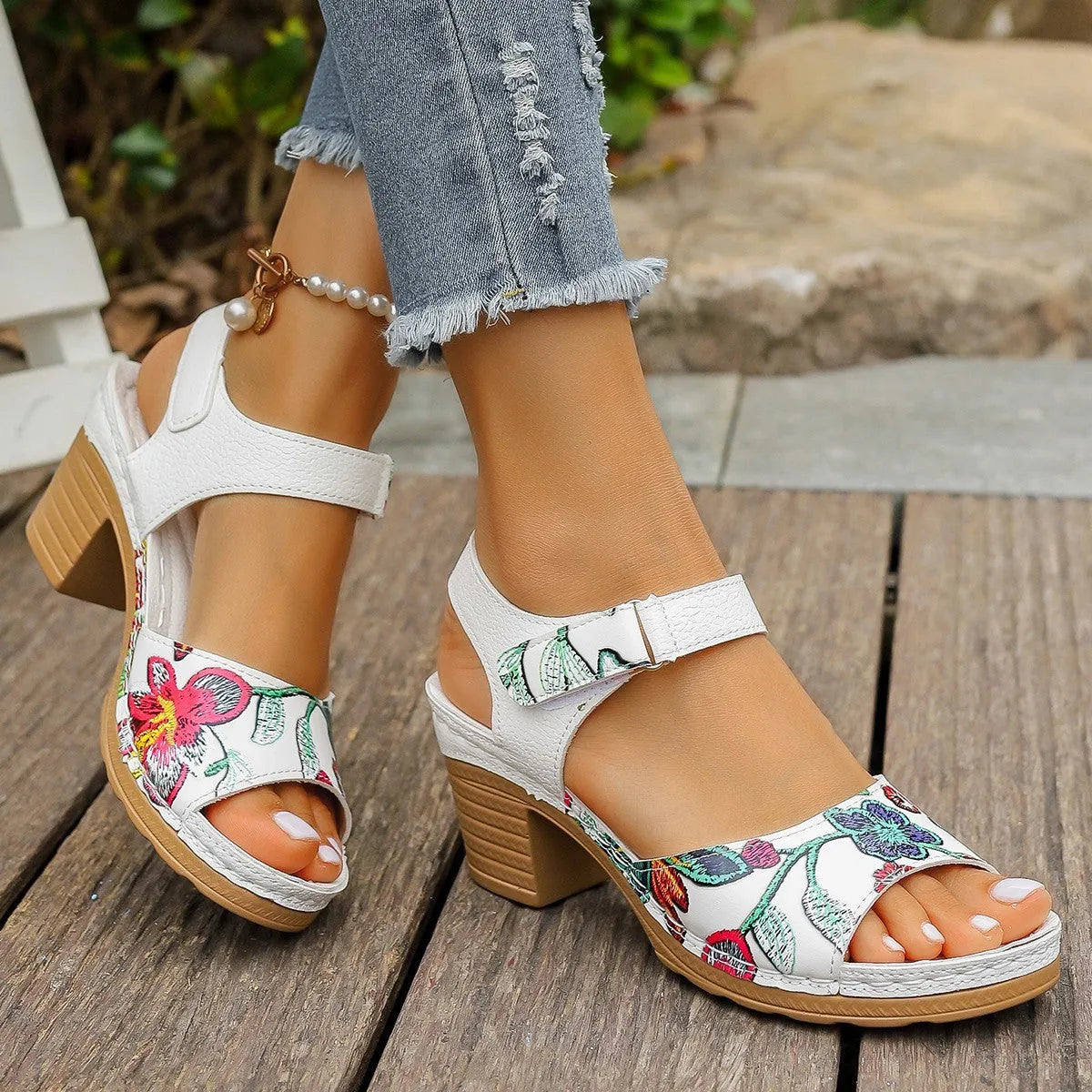 White women's high heel sandals showing velcro buckle fastening and rubber sole