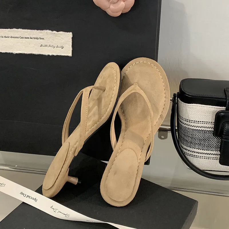 Women's black rubber stiletto flip-flops with round toe and flat head cap on a plain background.