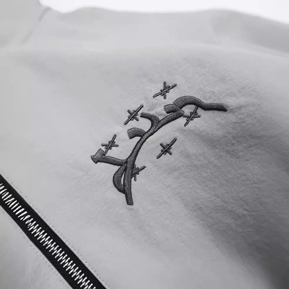 A grey men's hooded loose-fit casual jacket on a hanger.