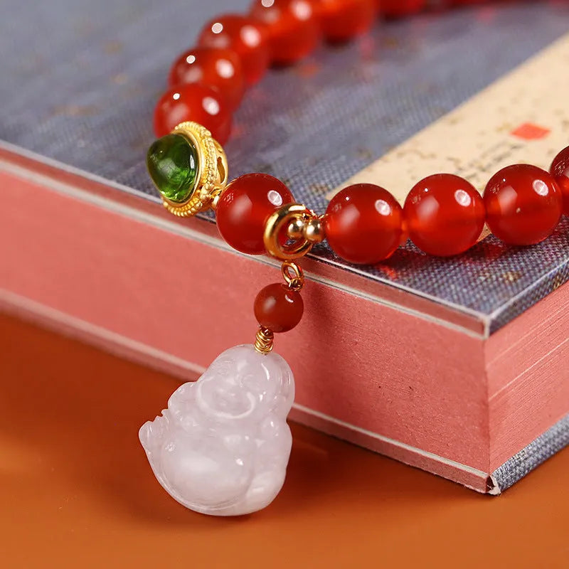 Chinese style geometric women's bracelet with red agate beads and a gold jade Maitreya Buddha pendant.