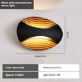 Modern minimalist aluminium wall lamp in black finish with LED light, mounted on a white wall.