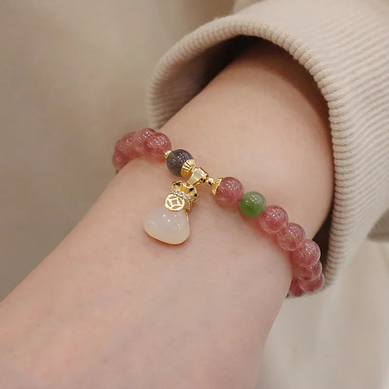Women's strawberry quartz bracelet with geometric design, purse charm, and safety buckle closure