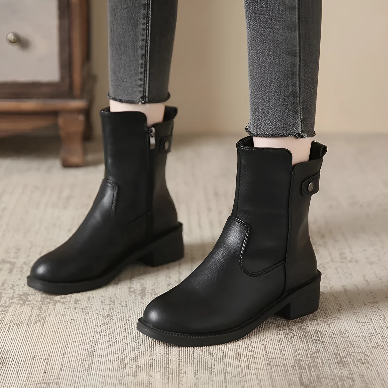 Black women's ankle boots with side zip, round toe, and a low rubber sole.
