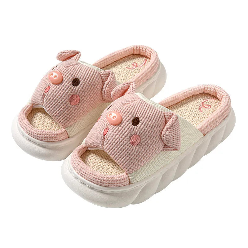 Pair of piggy cute open toe linen flip flop slippers for couples on a plain background.