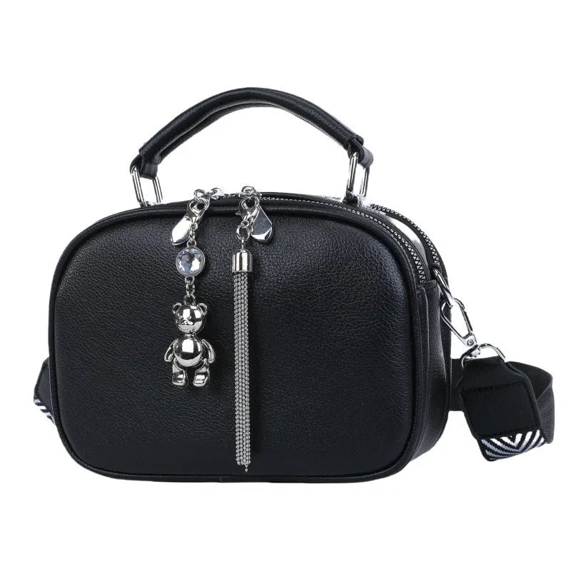 Oval-shaped women's small square bag in PU with double shoulder strap and internal phone pocket.
