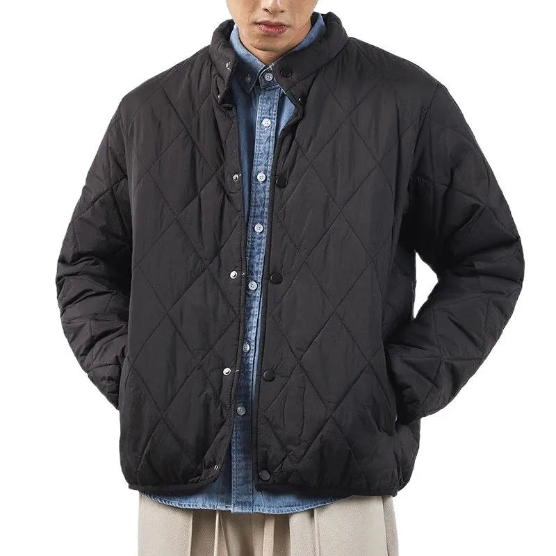 Man wearing a long black diamond quilted padded winter jacket with a loose fit.