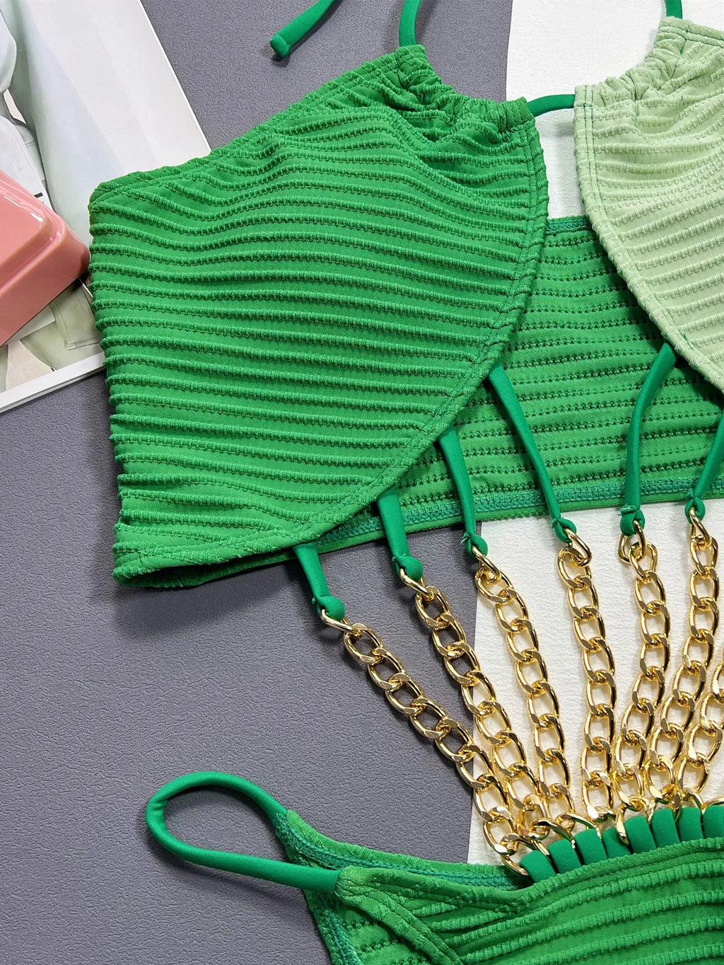 Green women's one-piece swimsuit with a hollow cutout design on a mannequin