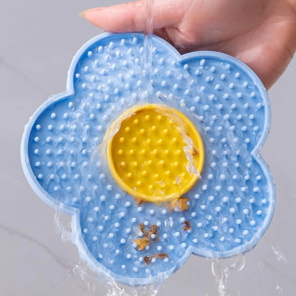 Flower-shaped silicone slow feeder licking mat for dogs and cats with suction cups on a smooth surface.