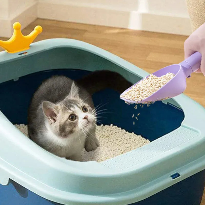 White ABS plastic cat litter scoop standing on a matching storage base with integrated waste bag roll.