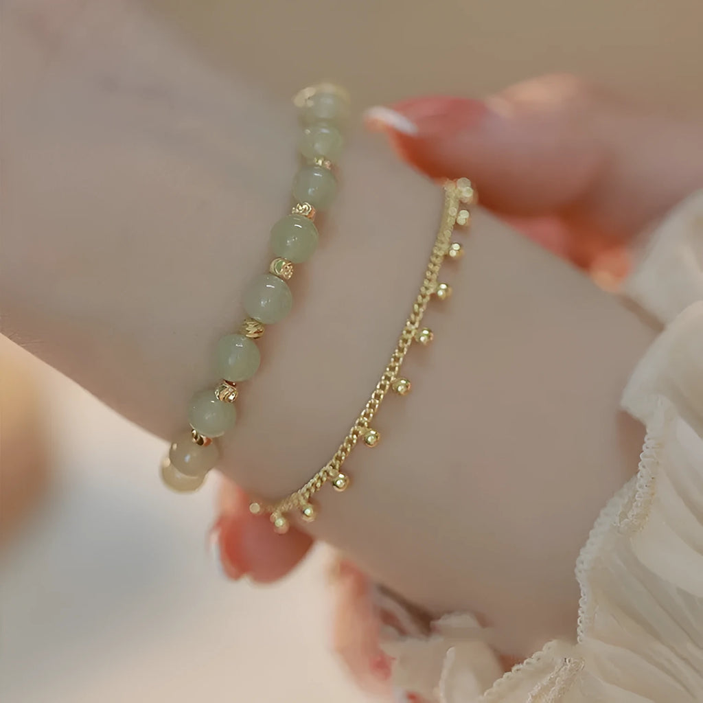 Natural Hetian Jade beaded bracelet with princess running motif on a wrist.