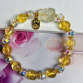 Close-up of an adjustable natural citrine crystal bracelet featuring a handcrafted nine-tail fox design on a white background.
