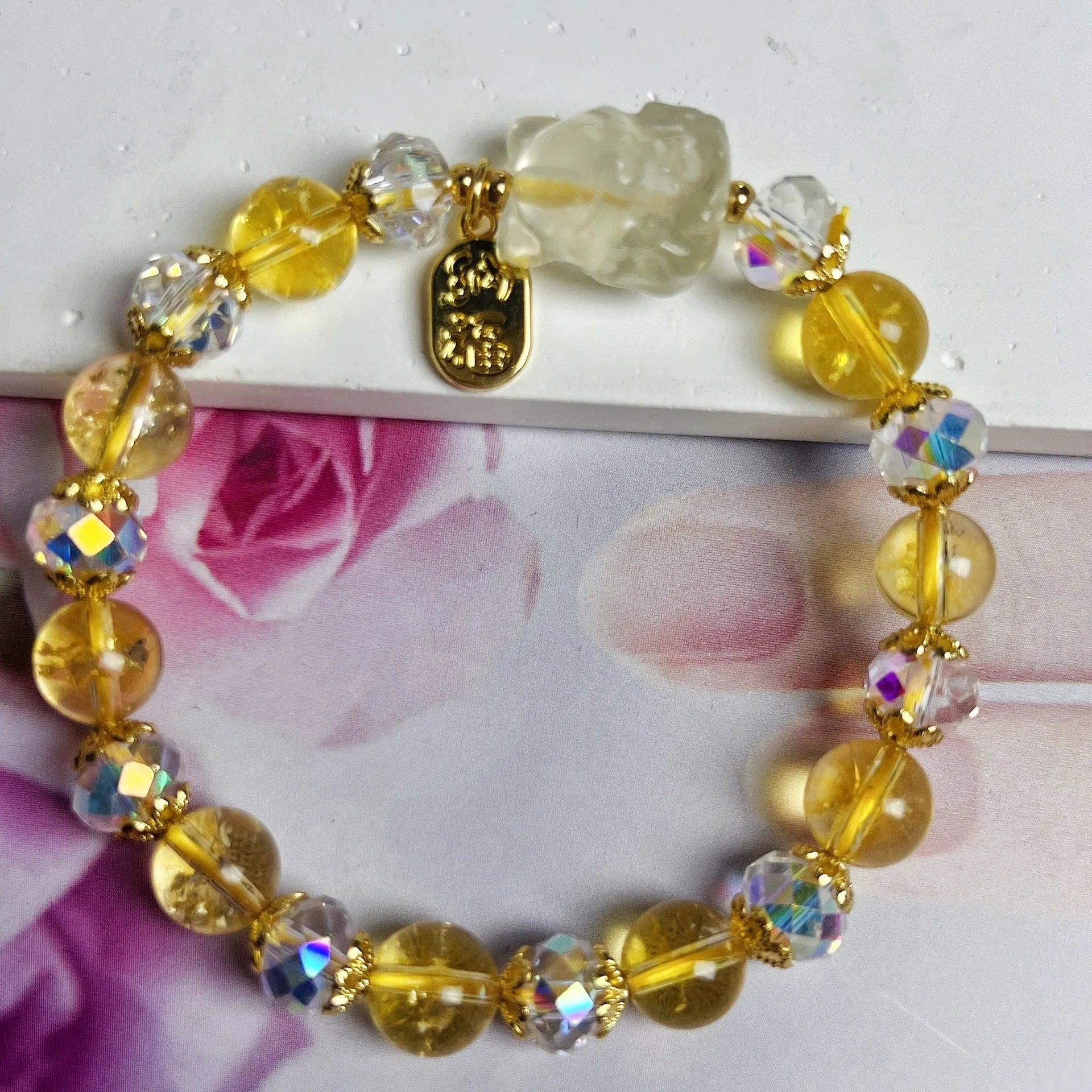 Close-up of an adjustable natural citrine crystal bracelet featuring a handcrafted nine-tail fox design on a white background.