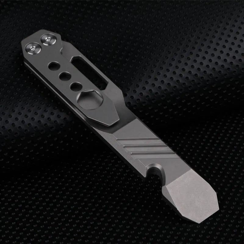 Titanium multi-function crowbar tool with screwdriver tip and bottle opener, shown in stone wash and gun grey finishes.