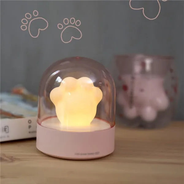 Grey cat paw shaped night light with USB charging port and control button showing soft illumination