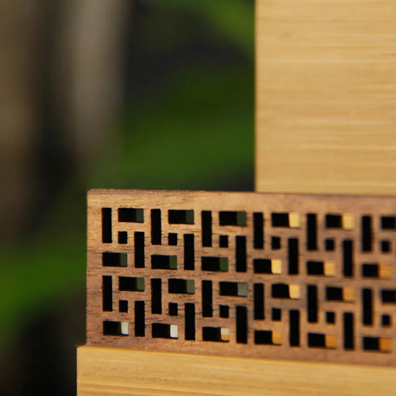 Geometric bamboo business card holder on a desk, showing natural wood grain and card slots.