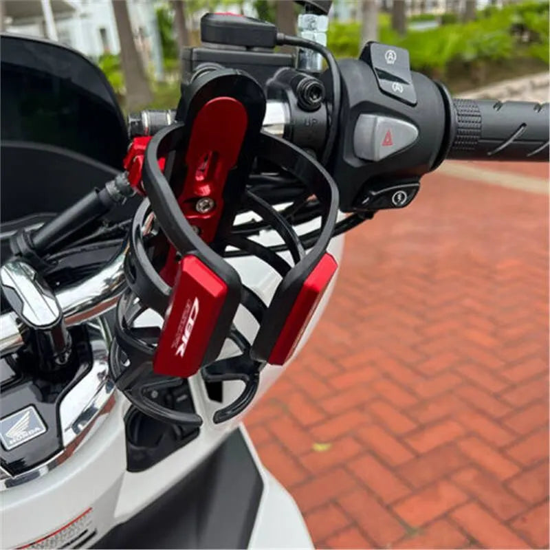 Modified water bottle cage mounted on Honda X-ADV scooter bumper in titanium colour