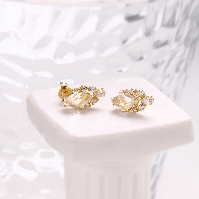 Geometric silver earrings with sweet white crystal studs showing structured design