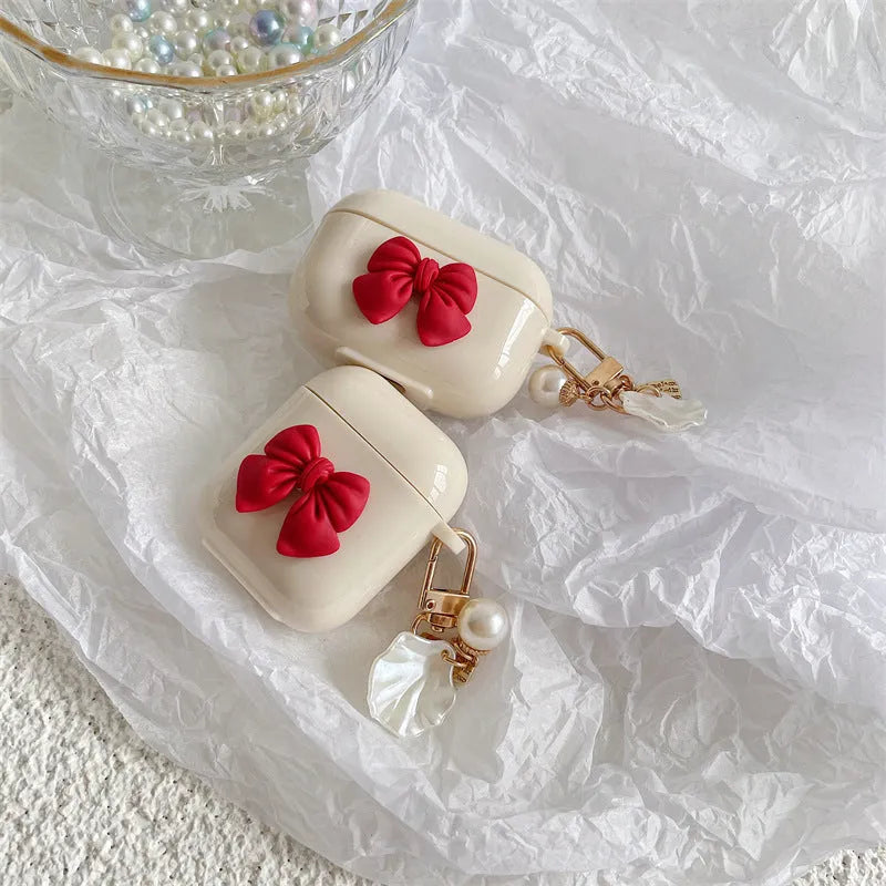 Beige TPU clamshell earphone case with a red bow design for AirPods.