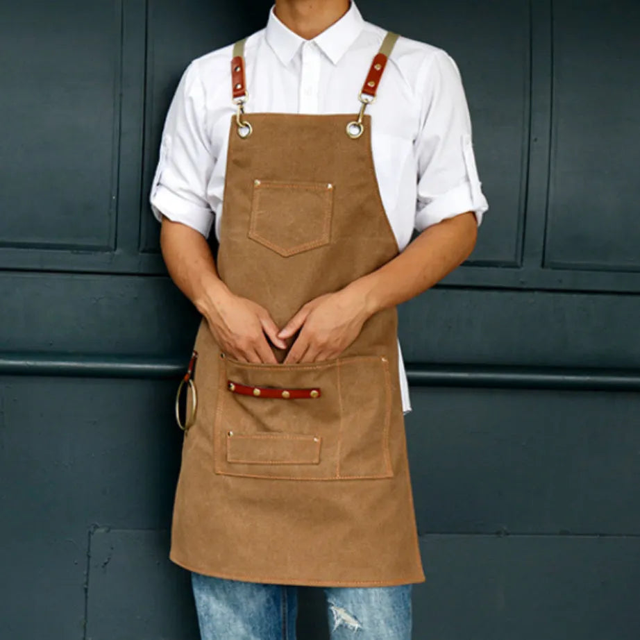 Canvas apron with cross-back straps in camel colour, shown on a person for milk tea shop or cafe use