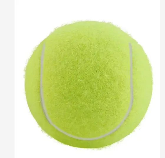 A 6.3cm pink rubber dog tennis ball sitting on grass.