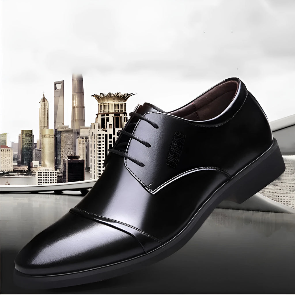 Men's black leather lace-up shoe with decorative stitching and a horse buckle on a rubber sole.
