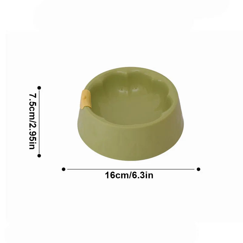 Flower-shaped green plastic double pet bowl for cat and dog food and water on a white surface.