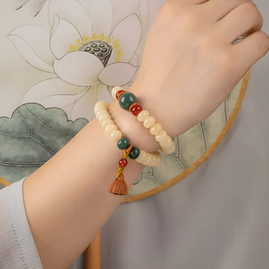 Cream topaz wooden bodhi root bracelet with 6x9mm flat round beads on wrist