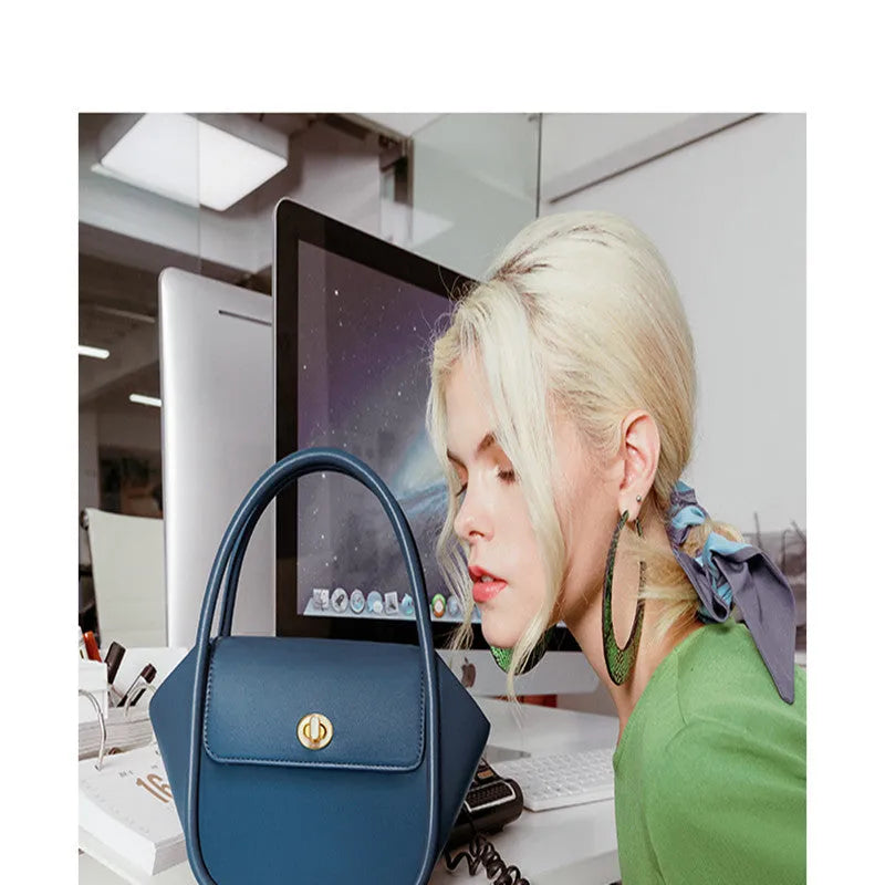 Leather tote cross-body wing bag in soft cow leather with latch closure and wing shape design.