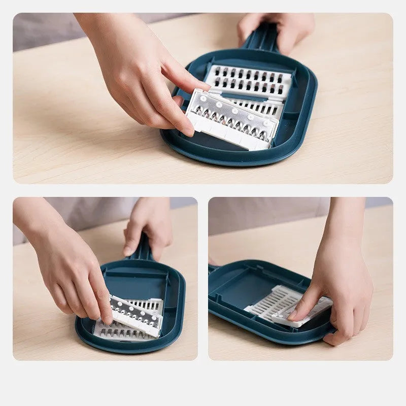 Dark blue vegetable cutter kitchen tool with hand guard, four stainless steel blades, and a white drain basket.