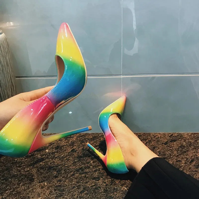 Rainbow coloured patent leather high heels with a pointed toe and a thin ultra-high heel.