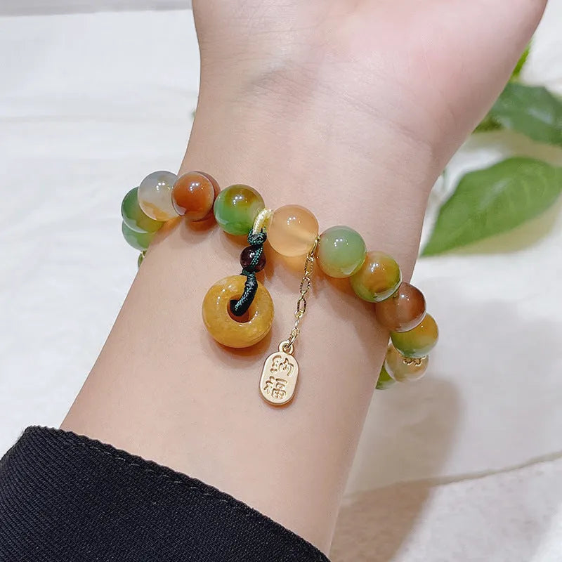 Yellow peacock agate and topaz bracelet with a peace buckle clasp and a lutong agate charm.