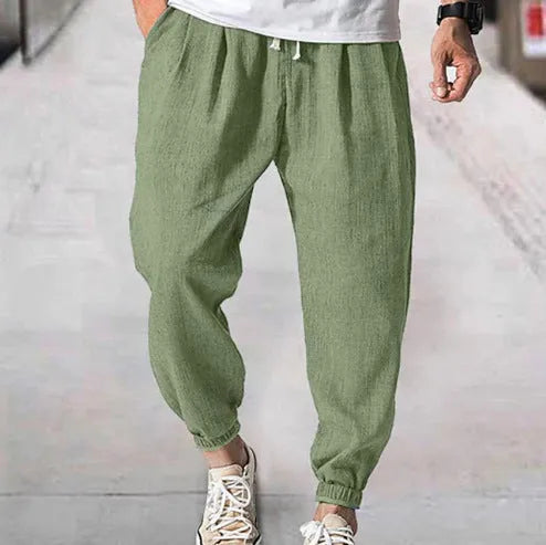 Man wearing loose light-coloured cotton trousers with a banded ankle cuff