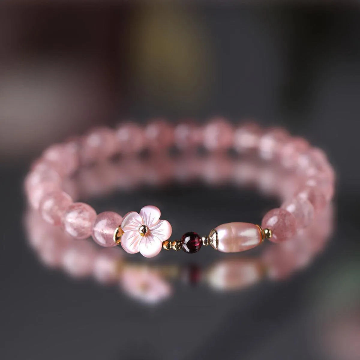 Strawberry quartz crystal bracelet with peach blossom floral design on wrist, showing adjustable 18-20cm length