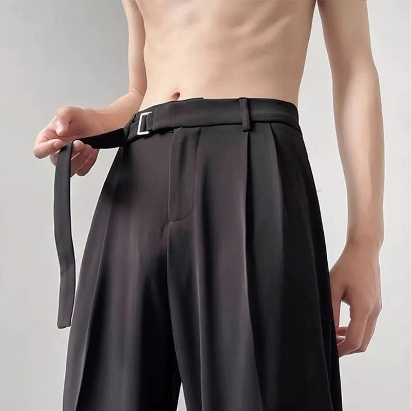 A woman wearing thin black wide-leg straight trousers with a loose, casual fit.