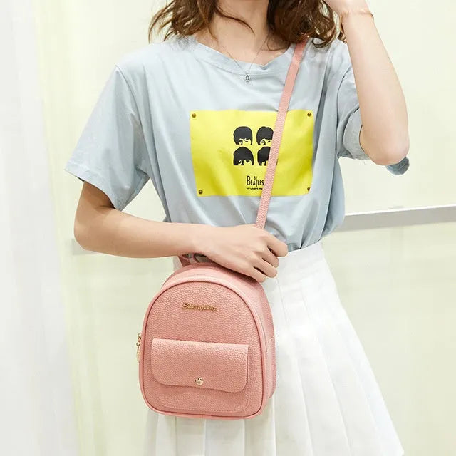 Women's small black backpack purse with adjustable straps showing 18.5cm length and zipper closure