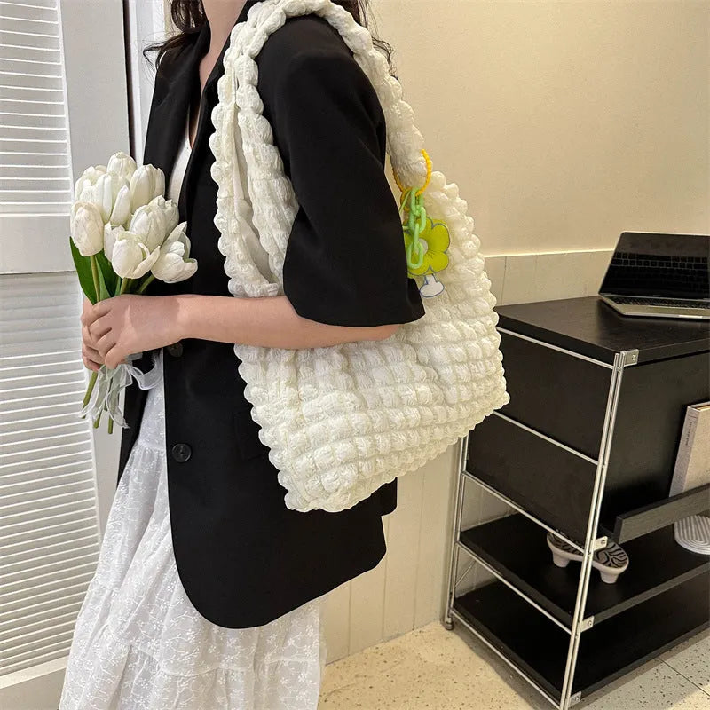 Soft square polyester shoulder bag with pleated bubble texture and an optional pendant, shown in multiple colours.