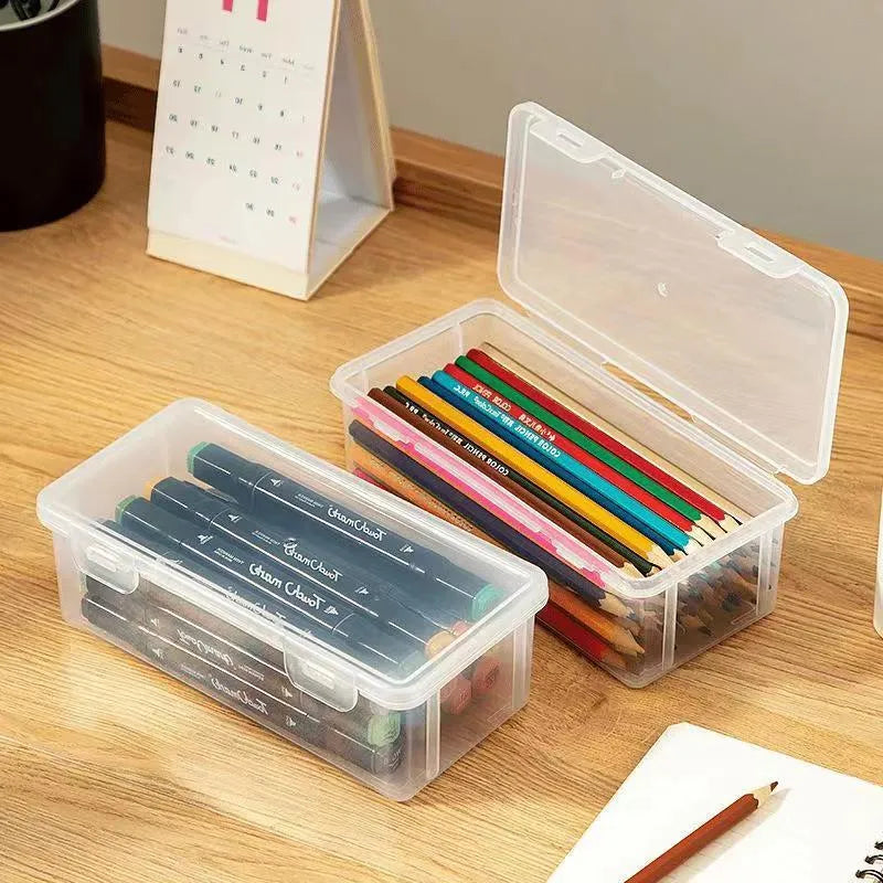 Transparent plastic stationery storage box with snap-lock lid containing coloured pencils and pens