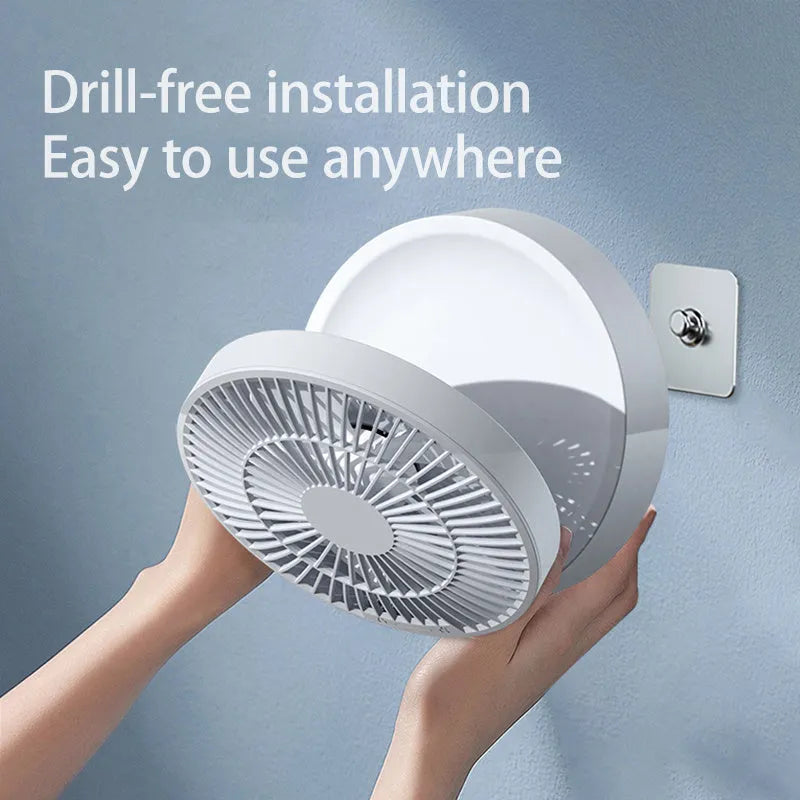 White portable USB rechargeable fan with remote control on a desk, showing its folding head and night light.