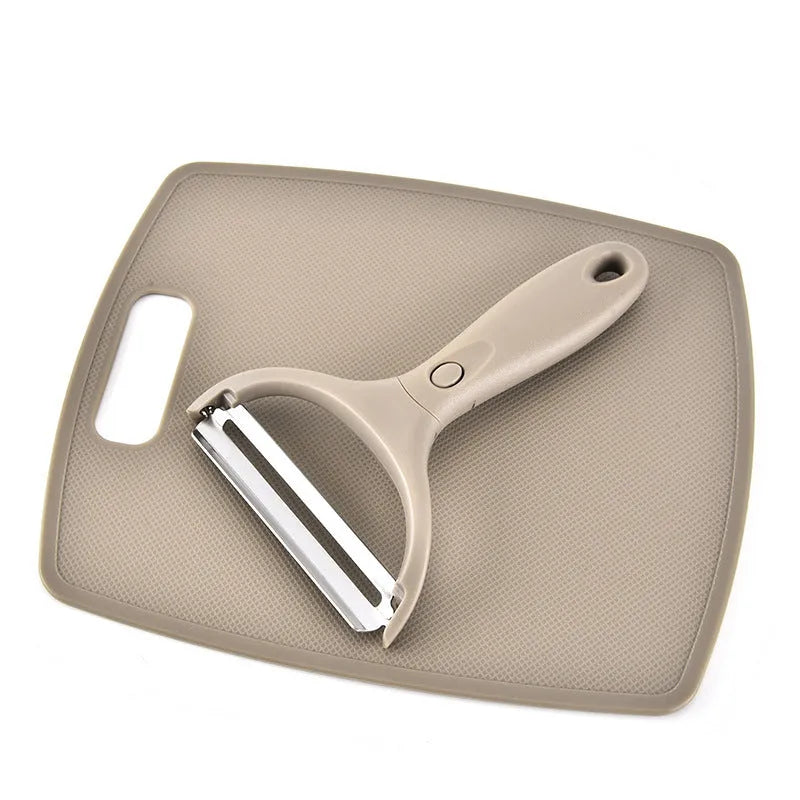 Green eight-piece kitchen tool set with peeler, cutter, and wheat straw chopping board on a counter.