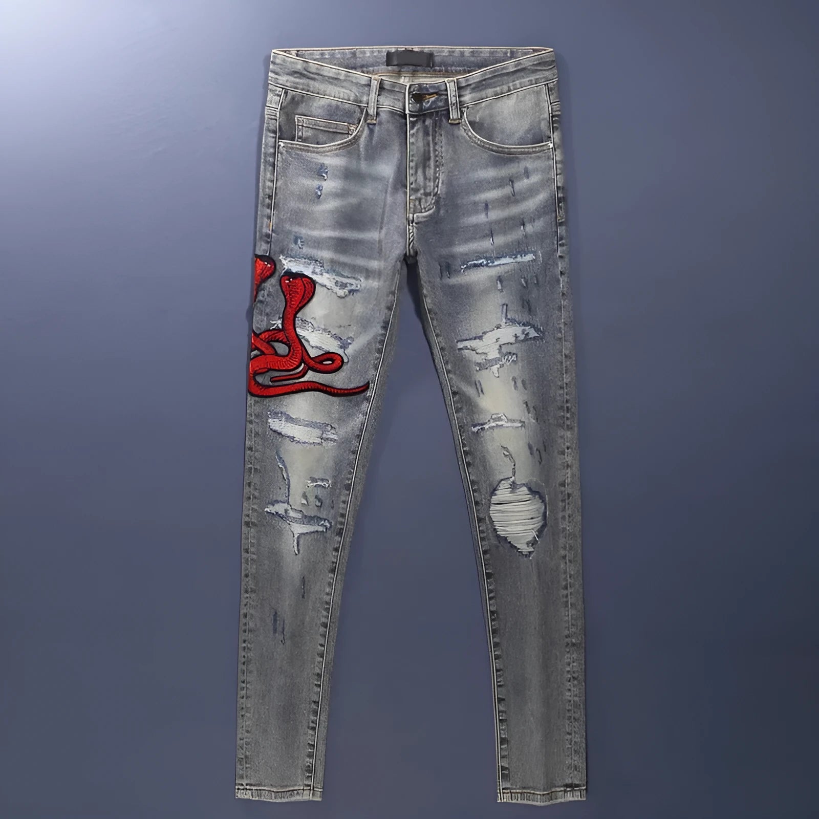 Men's slim fit distressed jeans with embroidered patches in an old colour wash.