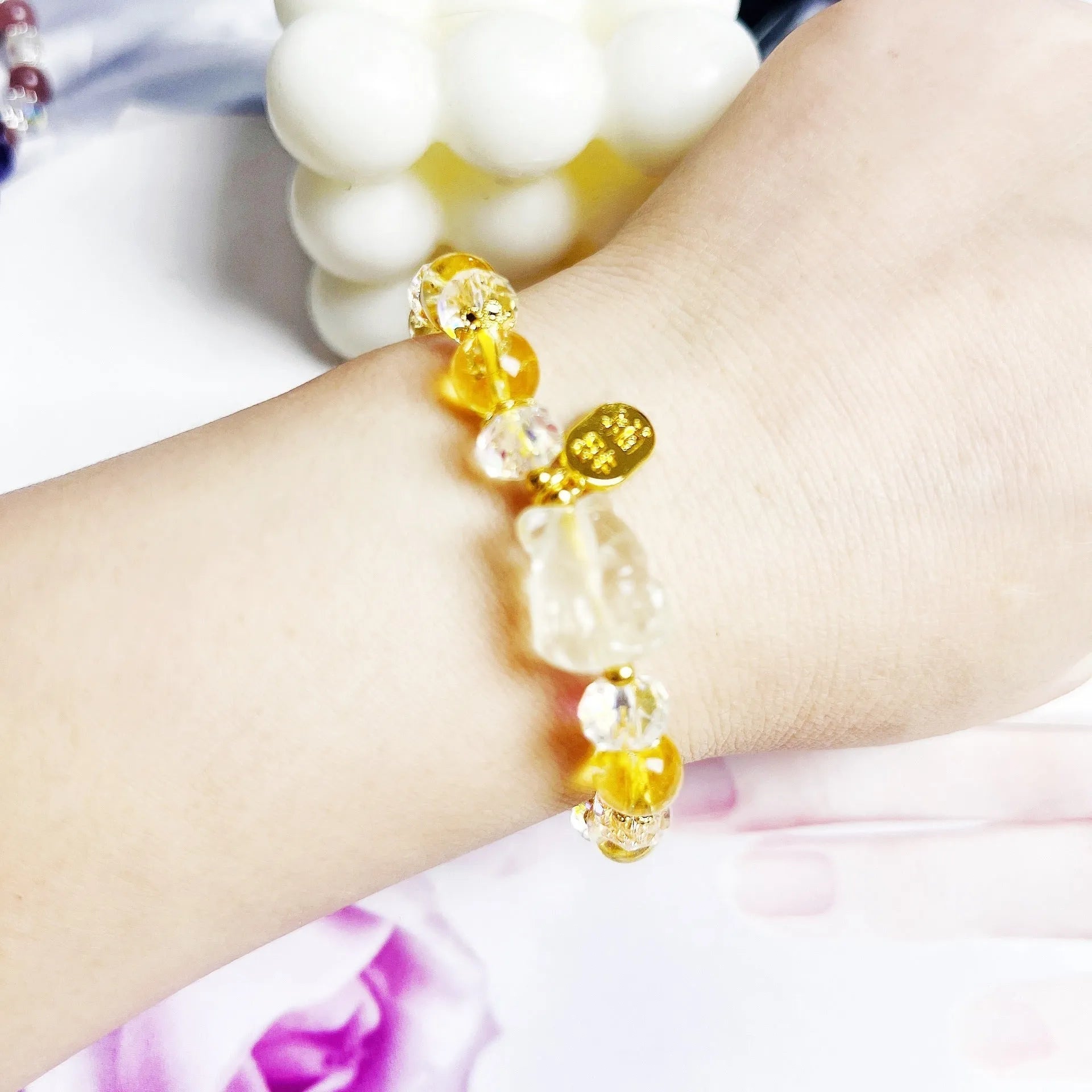 Close-up of an adjustable natural citrine crystal bracelet featuring a handcrafted nine-tail fox design on a white background.