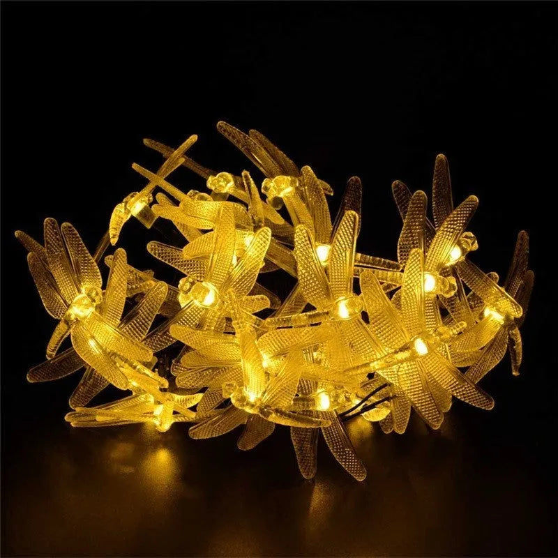 5-metre long solar-powered dragonfly string lights with warm white LEDs and a ground-spike solar panel for outdoor use.
