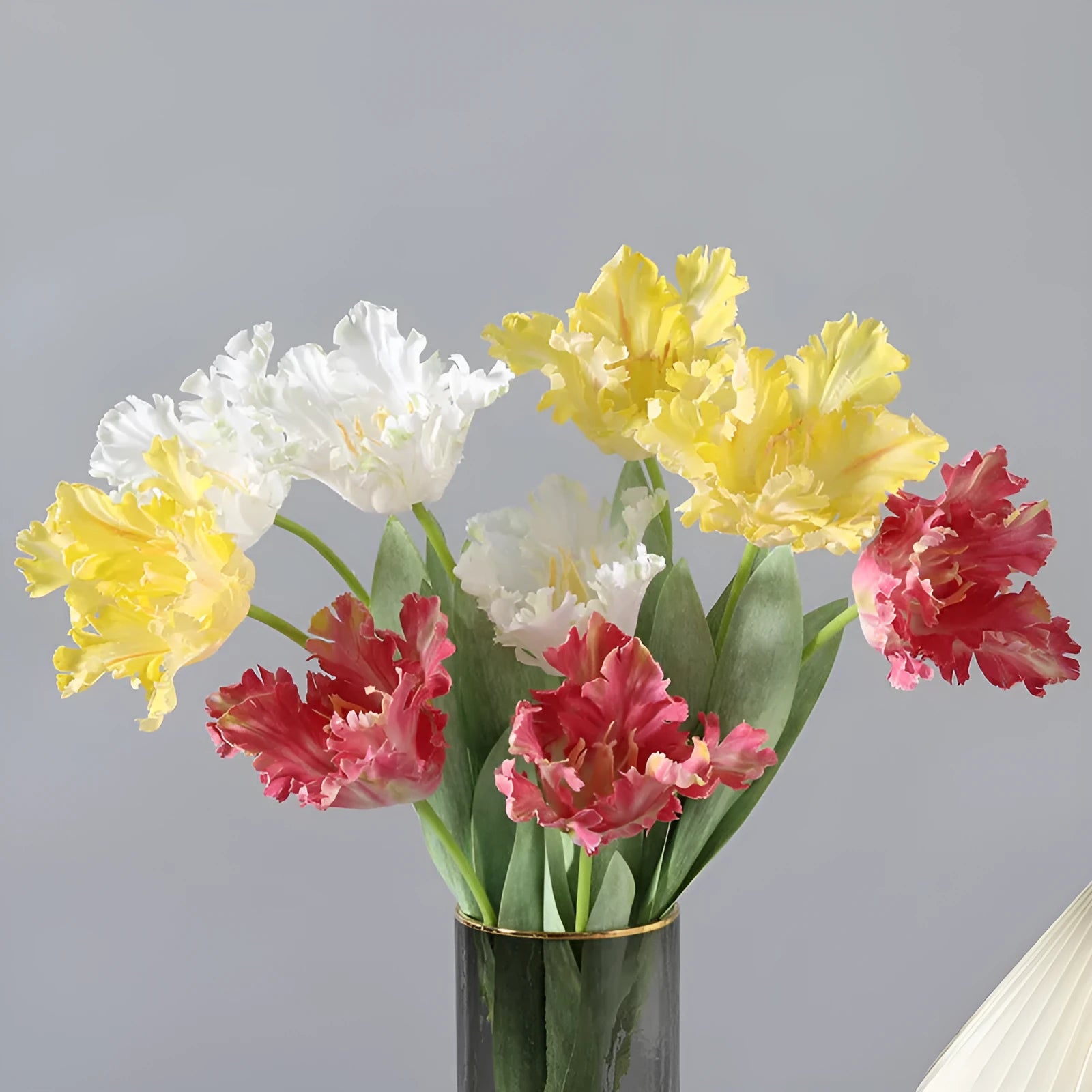Artificial toothed tulip fake flower arrangement in bright red colour on wooden table