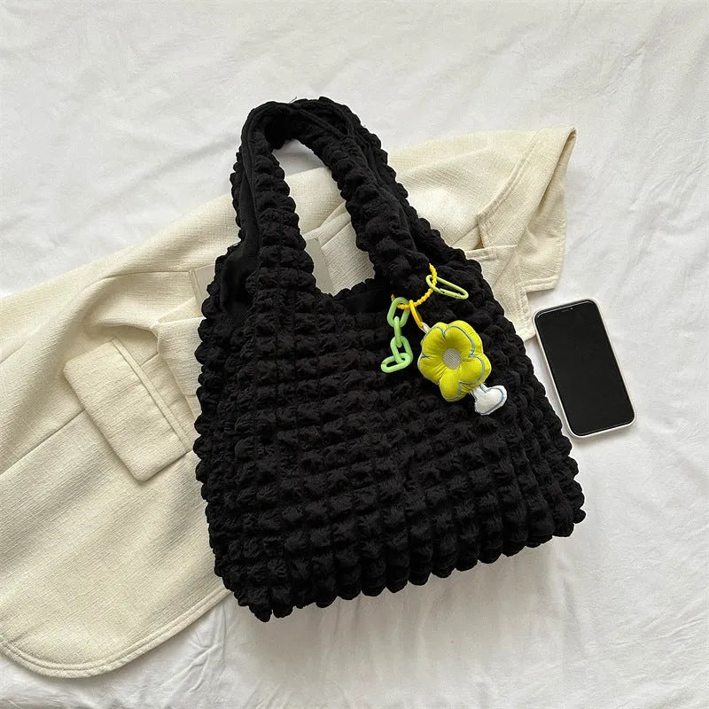 Soft square polyester shoulder bag with pleated bubble texture and an optional pendant, shown in multiple colours.