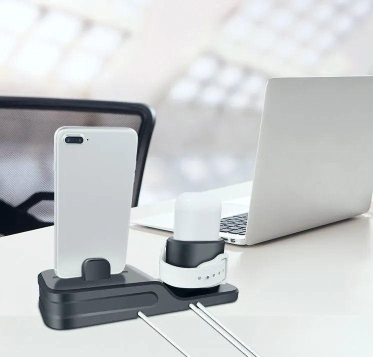 Black silicone 3-in-1 charging stand for iPhone, iWatch, and AirPods on a desk