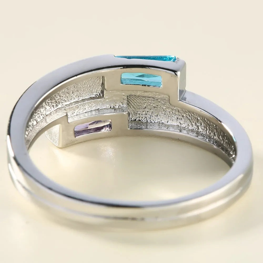 Silver-coloured copper ring with a central zircon stone, shown on a hand.