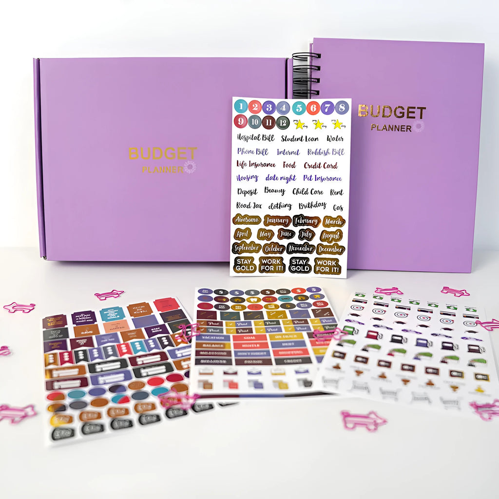 Purple coil-bound financial planning notebook open on a monthly budget page with pen and stickers.