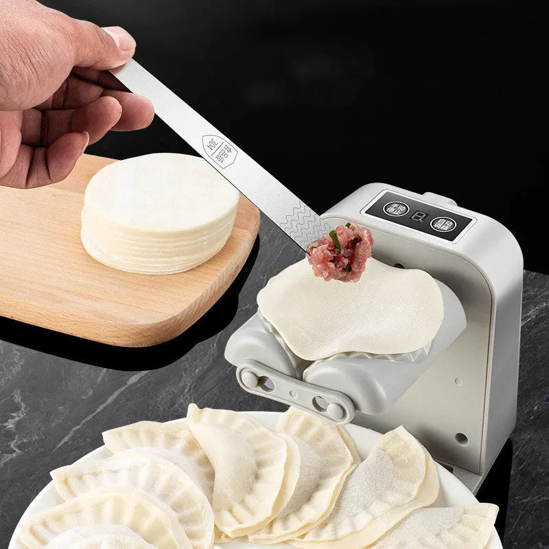 White electric dumpling maker machine with USB charging cable, brush, and spoon.